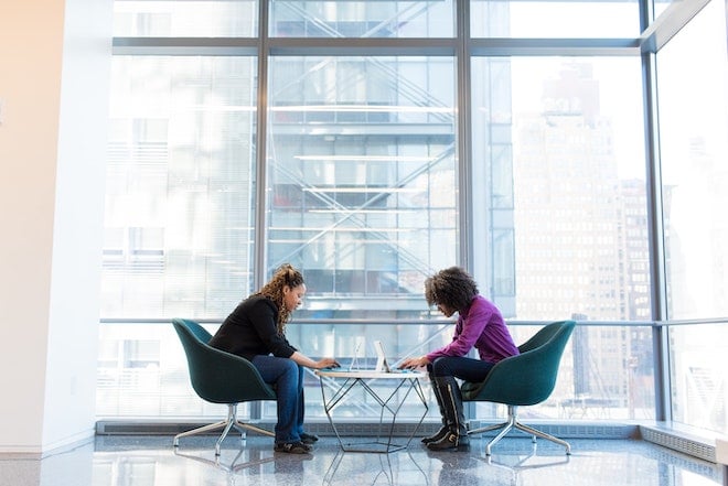 two business partners working together at table