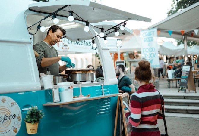 man serving food at food truck business