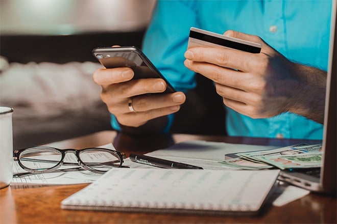 man holding credit card and smartphone